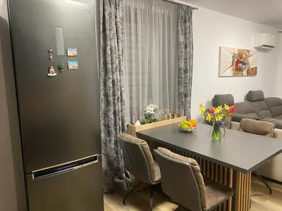 a kitchen and living room with a table and a refrigerator at Sea Sunrise Apartment in Burgas City