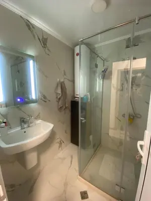 a bathroom with a glass shower and a sink at Sea Sunrise Apartment in Burgas City
