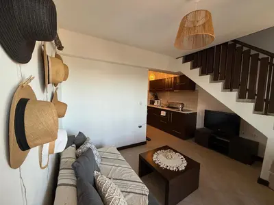 a living room with a couch and a staircase at Cosy Seaview apartment Budjaka in Sozopol