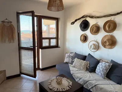 a living room with a couch and hats on the wall at Cosy Seaview apartment Budjaka in Sozopol