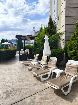 a row of chaise lounge chairs and an umbrella at Excellent apartment on the 6th floor in Sunny Beach