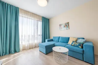 a living room with a blue couch and a table at Blue Horizon Suite in Varna City