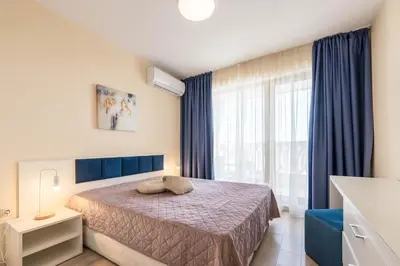 a bedroom with a bed and a large window at Blue Horizon Suite in Varna City