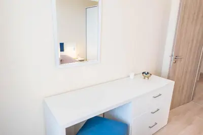 a white dressing table with a mirror and a blue stool at Blue Horizon Suite in Varna City