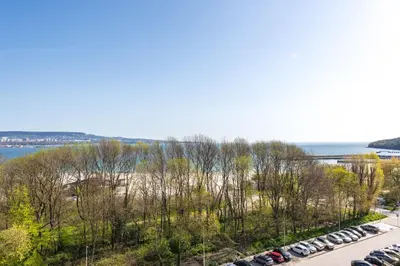 a row of cars parked in a parking lot near the water at Blue Horizon Suite in Varna City