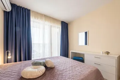 a bedroom with a bed with a large window at Blue Horizon Suite in Varna City
