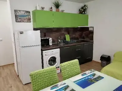 a kitchen with green cabinets and a washing machine at Path ways to the Sea -Пътека към морето in Primorsko
