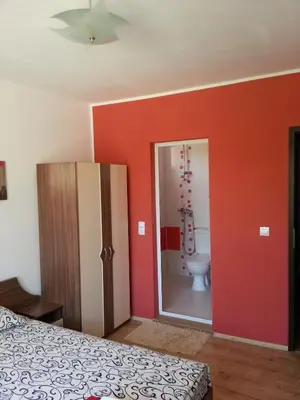 a bedroom with a bed and a bathroom with a toilet at Guest House Nedelchevi in Primorsko