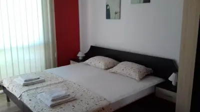 a bedroom with a bed with white sheets and pillows at Guest House Nedelchevi in Primorsko