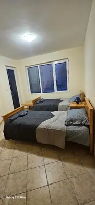 two beds in a room with three windows at Apartament Prestig Sity in Sunny Beach