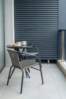 a table with two chairs and two cups on it at ВХТИ Park - Premium Apartment in Burgas City