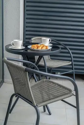 a table with two chairs and two cups and a plate of food at ВХТИ Park - Premium Apartment in Burgas City