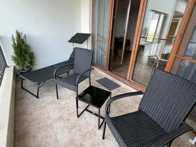 a patio with chairs and a table and a table and chairs at Family Apartment with Sea View Vineyard Spa Resort Aheloy in Aheloy