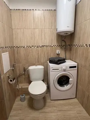 a bathroom with a toilet and a washing machine at Family Apartment with Sea View Vineyard Spa Resort Aheloy in Aheloy