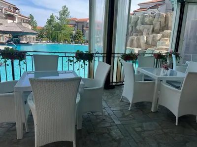 a patio with tables and chairs and a view of the water at Family Apartment with Sea View Vineyard Spa Resort Aheloy in Aheloy