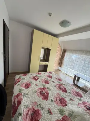 a bedroom with a bed with a floral bedspread at Sea View Apartment Sveti Vlas 1 Bedroom K&R in Sveti Vlas