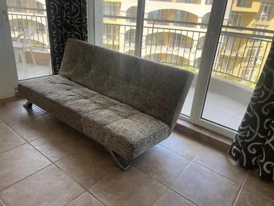 a couch sitting in front of a window at The Royal Bay Hideaway Studio in Aheloy