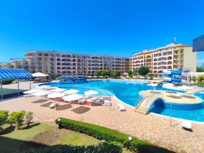 a large swimming pool with chairs and umbrellas in a resort at The Royal Bay Hideaway Studio in Aheloy