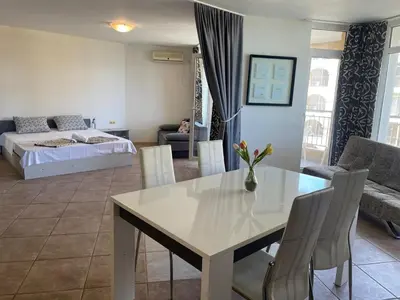 a living room with a table and a bed at The Royal Bay Hideaway Studio in Aheloy