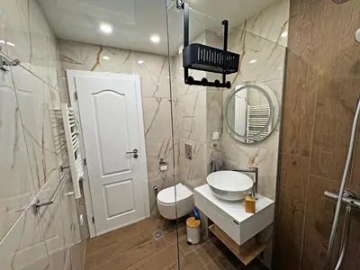 a bathroom with a toilet and a sink and a mirror at AURA BEACH apartment in Burgas City
