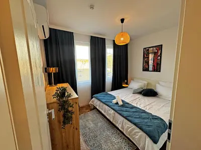a small bedroom with a bed and a window at AURA BEACH apartment in Burgas City