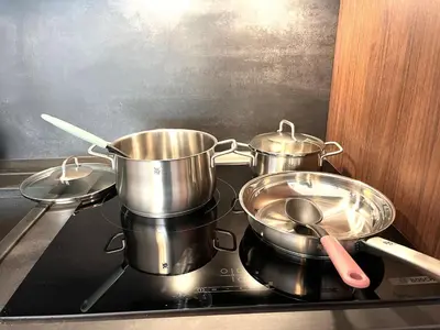 three pots and pans sitting on top of a stove at Miramar Front Beach Family Deluxe Studios No Swim Pool Access in Sunny Beach