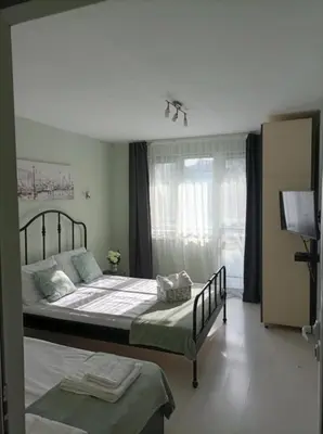 a bedroom with a large bed and a window at Apartment Maria Luisa in Burgas City