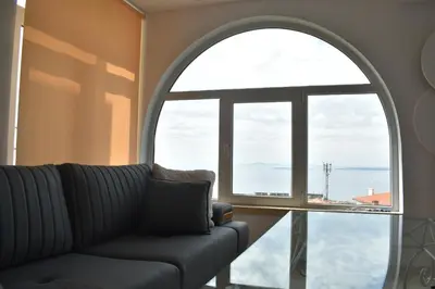 a living room with a couch and a large window at Вlue horizon in Sveti Vlas