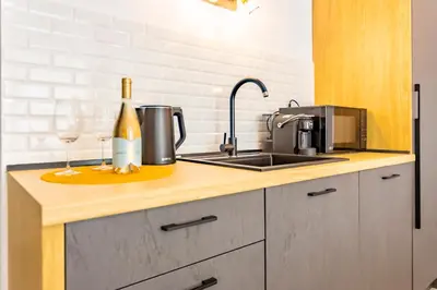 a kitchen counter with a sink and a bottle of wine at J'ADORE Secret Garden A&K Deluxe Studio in Sunny Beach