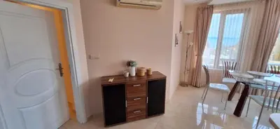 a living room with a washing machine and a table at Сарафово холидейс in Burgas City