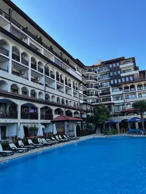 a large hotel with a swimming pool in front of a building at Amphora studio 209 in Sveti Vlas