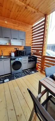 a kitchen with white appliances in a wooden room at Бунгало Шангри Ла - 1, плаж Градина in Sozopol