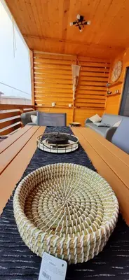 a room with a large wicker table on a boat at Бунгало Шангри Ла - 1, плаж Градина in Sozopol