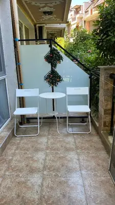a patio with two chairs and a table and a christmas tree at Слънчево Море in Nesebar