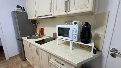 a small kitchen with a microwave and a sink at Слънчево Море in Nesebar