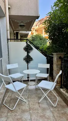 three chairs and a table and a tree on a patio at Слънчево Море in Nesebar