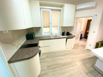 a kitchen with white cabinets and a sink at New Yorker 2 bedroom apartment in Varna City