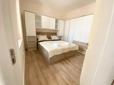a small bedroom with a bed and a large window at New Yorker 2 bedroom apartment in Varna City