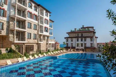 a hotel with a swimming pool in front of two buildings at Przytulny apartament w Sweti Vlas 350m od morza in Burgas City