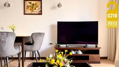 a living room with a tv and a table and chairs at ROYAL BEACH - Private Apartments - Center of Sunny Beach in Sunny Beach