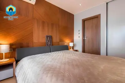 a bedroom with a bed and a wooden wall at Вилла Biala family haven in Byala