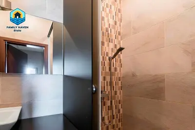 a bathroom with a shower with a tile wall at Вилла Biala family haven in Byala
