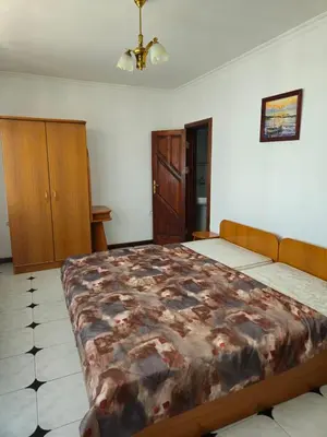 a bedroom with a large bed and wooden cabinets at Lazur Family Apartment Pomorie in Pomorie