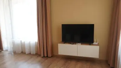 a flat screen tv sitting on a white cabinet in a room at Апартаменти Bella Deluxe in Ravda