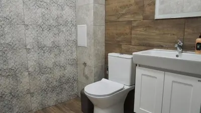a bathroom with a white toilet and a sink at Апартаменти Bella Deluxe in Ravda