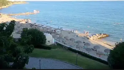 a beach with a bunch of umbrellas and the water at ETARA - 1 Rey&Mar Saint Vlas in Sveti Vlas