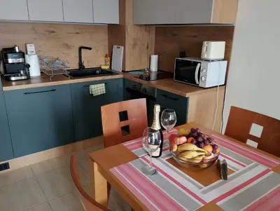 a kitchen with a table with a bowl of fruit and wine glasses at ETARA - 1 Rey&Mar Saint Vlas in Sveti Vlas
