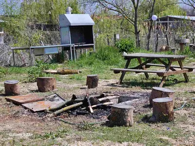 a picnic table and some logs and a grill at Бунгало Шангри Ла - 2, плаж Градина in Sozopol