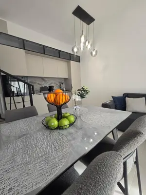 a dining room table with a bowl of fruit on it at Grand Villa Deluxe Apart in Sveti Vlas