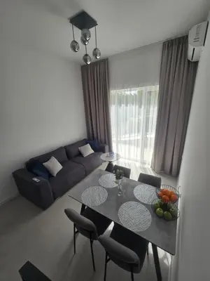 a living room with a table and chairs and a couch at Grand Villa Deluxe Apart in Sveti Vlas